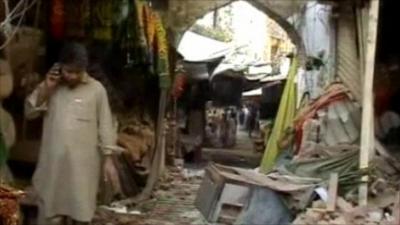 Man looks at wreckage after blast