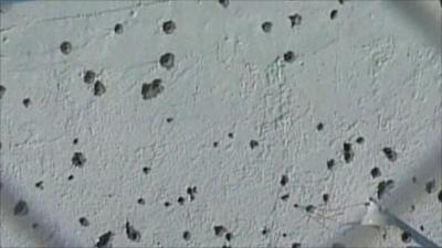 Wall riddled with bullet holes
