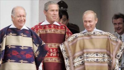 Former US President Bush (middle) and Russian President Vladimir Putin (right), wear Chilean ponchos