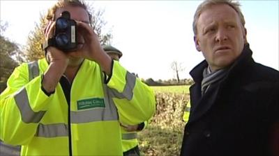 Volunteer monitors the speed of passing cars