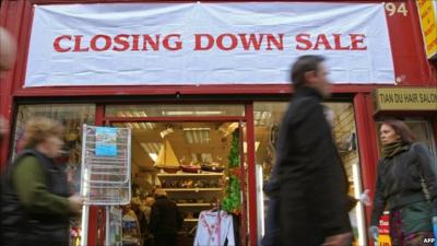 People walk past shop holding a closing down sale in Dublin