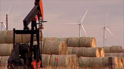 Oil pump with wind turbines in the background