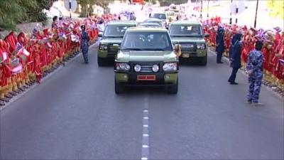 People line the street as the Queen is transported by car