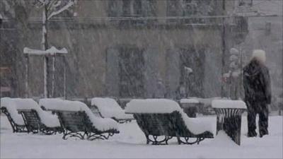 Benches in city square covered in thick snow