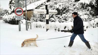 Man walking dog in snow