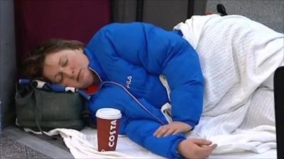 A stranded passenger sleeps in an airport