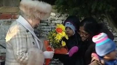 Queen accepts flowers from people at Sandringham