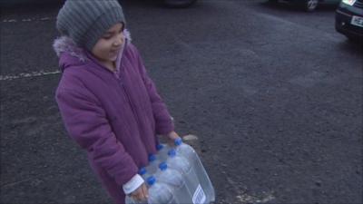 Girl carrying bottles of water