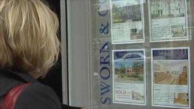 Woman looking in estate agents' window