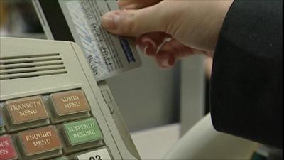 A credit card being swiped at a till