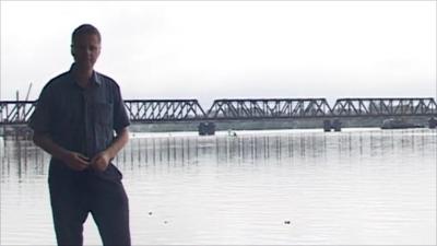 Charles Haviland standing next to flooding in Sri Lanka