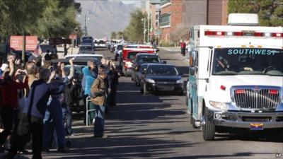 Well-wishers waving at the ambulance