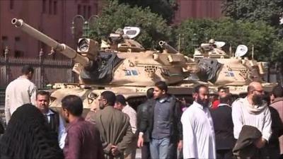 Crowds stand by tanks in Tahrir Square