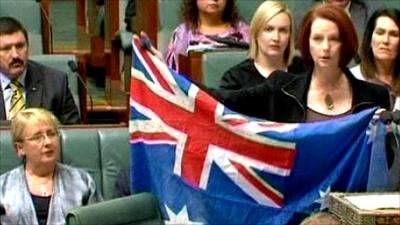 Julia Gillard holds up an Australian flag