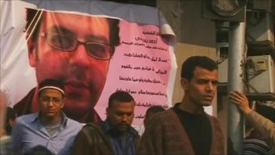 Protesters by a makeshift shrine of Ahmed Basiony, who was killed in Tahrir Square