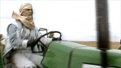 Muammar Gaddafi riding a tractor