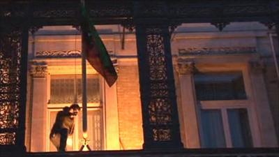 Protester removes flag from Libyan embassy in London