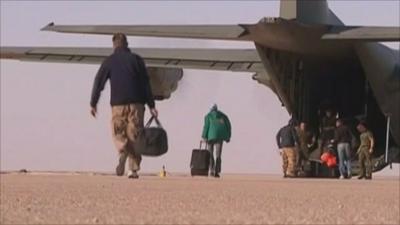 Oil workers board an RAF C130 Hercules