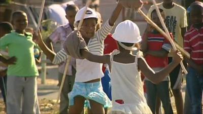 Children learning how to stick fight