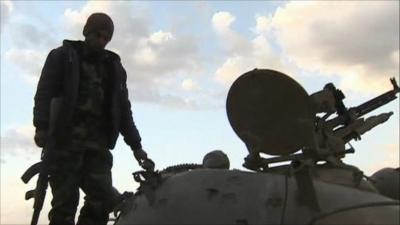 A rebel stands on a tank in Ajdabiya