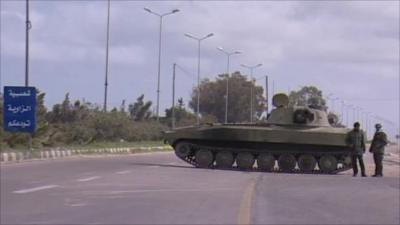 Military troops stand by tank on road into Zawiya