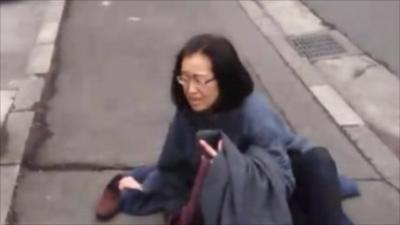 A woman gets to the ground as the quake strikes