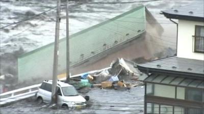 A building is swept away by the tsunami