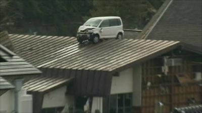 A car is perched on top of a building