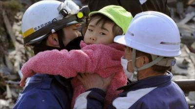 Rescuers carry a child