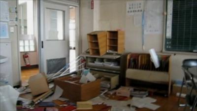 Shelves tipped over and paper on the floor of a staff room