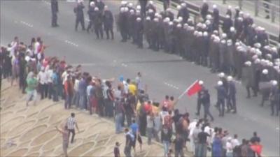 Protesters and police on a road in Manama