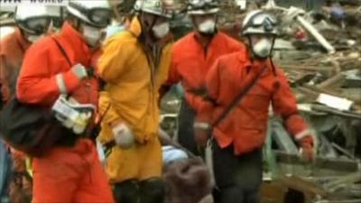 Rescue workers bring out survivor on stretcher