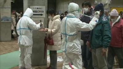 Men in protective suits checking residents