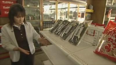 Shop owner stocks shelves in supermarket