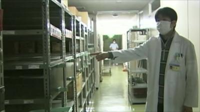 Doctor pointing towards empty shelves