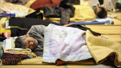 A man asleep on the floor of a relief centre