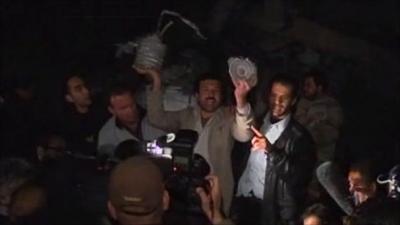 Men hold up debris claimed to be from coalition bombs to the press