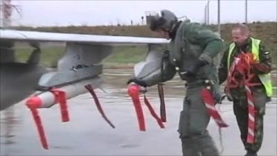 Pilot and another man checking missiles on jet fighter