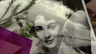 Flowers surround a photo of Elizabeth Taylor