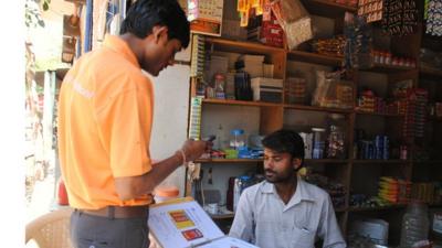 Sales representative taking an order from a shopkeeper