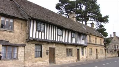 Cotswold stone houses by road in Gloucestershire