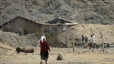 Tribesman walks at the site of an explosion at a bullet factory in the southern Yemeni town of Jaar