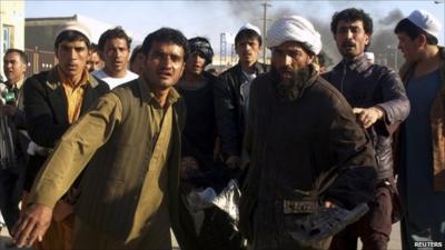 Afghan men carrying one of the injured