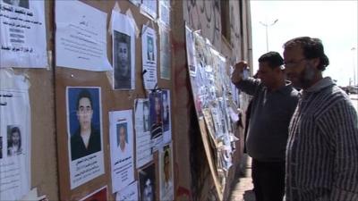Two men read a notice-board outside Benghazi's media centre