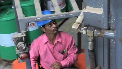 Man with barrels of oil