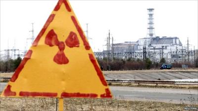Radiation sign and damaged fourth reactor at the Chernobyl nuclear power plant