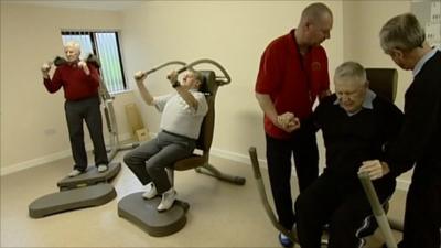 Dementia sufferers and care workers using gym equipment