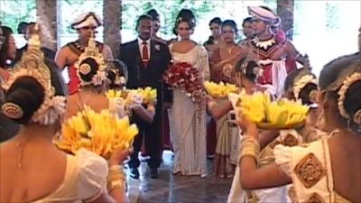 Sri Lankan bride is greeted by dancers at her wedding