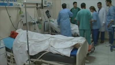 Hospital staff stand around patients bed in Misrata
