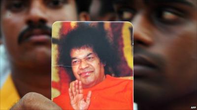 Man holding picture of Sri Satya Sai Baba